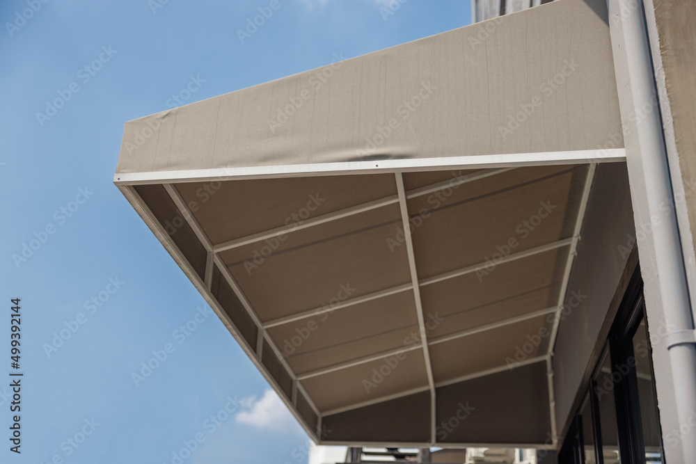 Wall mural brown awning over windows. canvas roof of shop.