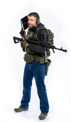 soldier, airsoft player in full gear works on a laptop in combat conditions. a man in headphones, a bulletproof vest, with a backpack and a belt, speaks, transmits information. White background.