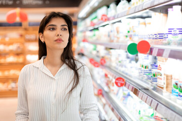 Arabic Woman Doing Grocery Shopping Standing Near Shelf In Supermarket