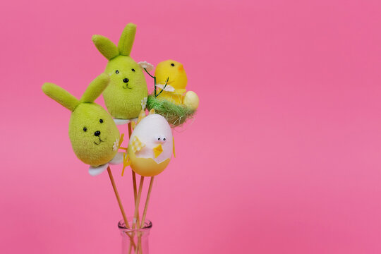 Bunnies and chickens toys on a pink background. Place for the inscription.