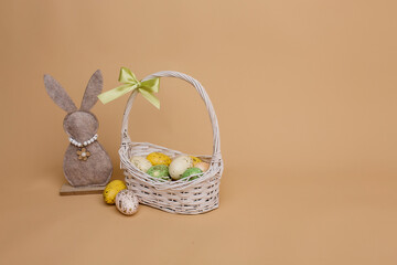 Colorful Easter eggs in a basket on a beige background.