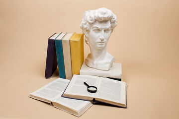 A stack of books with a magnifying glass highlighted on a beige background. Search for information.