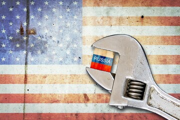 Flag of Russia on a wooden block, clamped with a wrench, against the background of the flag of...