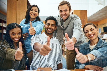 Our studies are going great. Cropped portrait of a group of university students showing you thumbs up while studying in the library.