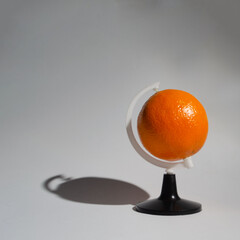 .Orange as a planet of the earth as a globe, on a white background, symbolizes the global trade in this fruit