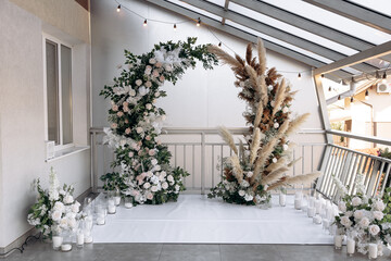 Fototapeta na wymiar Luxury wedding arch at a banquet in the style of boho. Live plants and decorative light