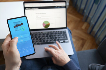 Man using online banking on mobile phone screen. Online bank login on a touch screen device. Digital and internet payments shopping on network connection. Mobile online banking concept.