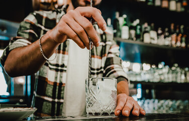 man hand bartender making glass negroni cocktail in bar