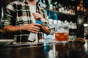 man hand bartender making glass negroni cocktail in bar