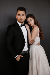 Wedding couple in love. Beautiful bride and elegant groom on black background. Stylish newlywed couple. Marriage concept
