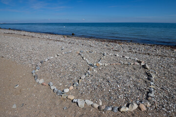 Peace symbol made out of stones on a beach, solidarity