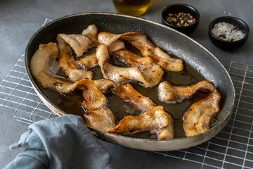 Fried crunchy slices of streaky bacon fried in skillet