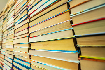 close up to the wall of old books stack. educational colorful used books folded in many pile columns. Collecting in the library and how to choose only one book horizontal