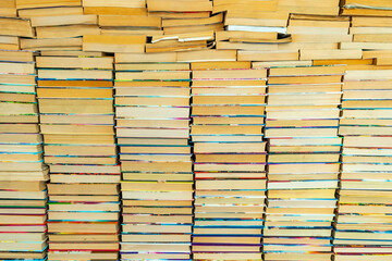Endless wall of old books stack background. Colorful educational used books folded in many pile columns. Collecting in the library and how to choose only one book horizontal
