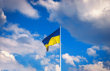 Developing Ukrainian flag against the background of the sky with clouds