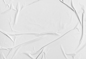 Fototapeta premium Blank white crumpled paper poster texture background. White paper wrinkled poster template, white paper sticker poster mockup on wall concept