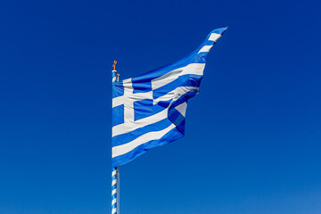 Greek flag on the blue sky background.