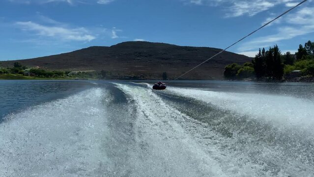 Man on tube behind speed boat on Bulshoek Dam, South Africa