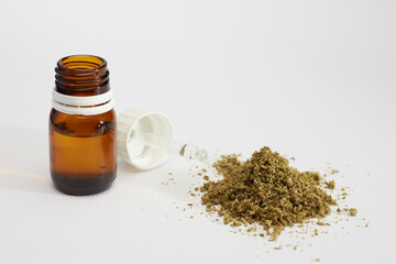 marijuana oil dropper bottle , crushed marijuana, white background