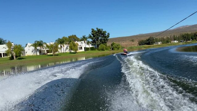 Woman on kneeboard behind speed boat on Bulshoek Dam, South Africa
