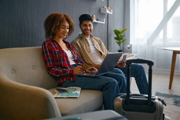 Couple pay for travel tickets on laptop