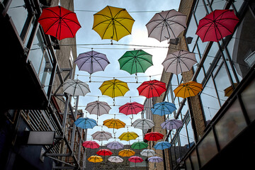 Cloudy sky and a lot of multi colored umbrellas on top of street in Dublin, Ireland