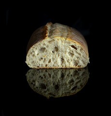 freshly baked artisan ciabatta bread on black mirror kitchen table. close up photo on the table