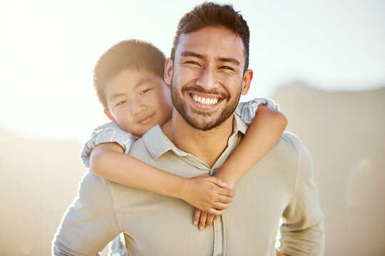 Spending some quality time with my boy. Cropped portrait of a handsome young man piggybacking his son on the beach.