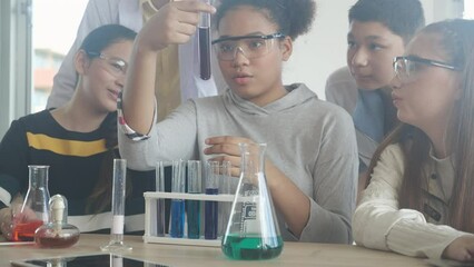 Young teacher teaching group student about science and explaining chemical for liquid in the lab of school, children studying and learning experiment science in the laboratory, education concept. - Powered by Adobe