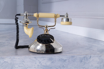 Old retro telephone on stone tiles