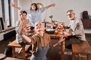 Senior people and their teacher taking photo at the mobile phone