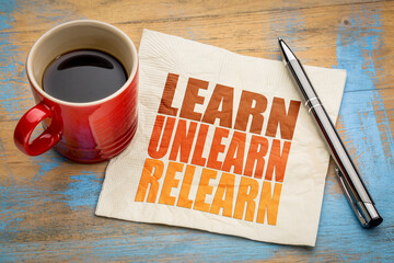 learn, unlearn, relearn - word abstract on a napkin with a cup of coffee, continuous learning,...
