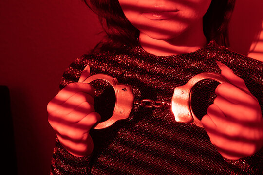 Frau mit Handschellen in Glitzer Rot