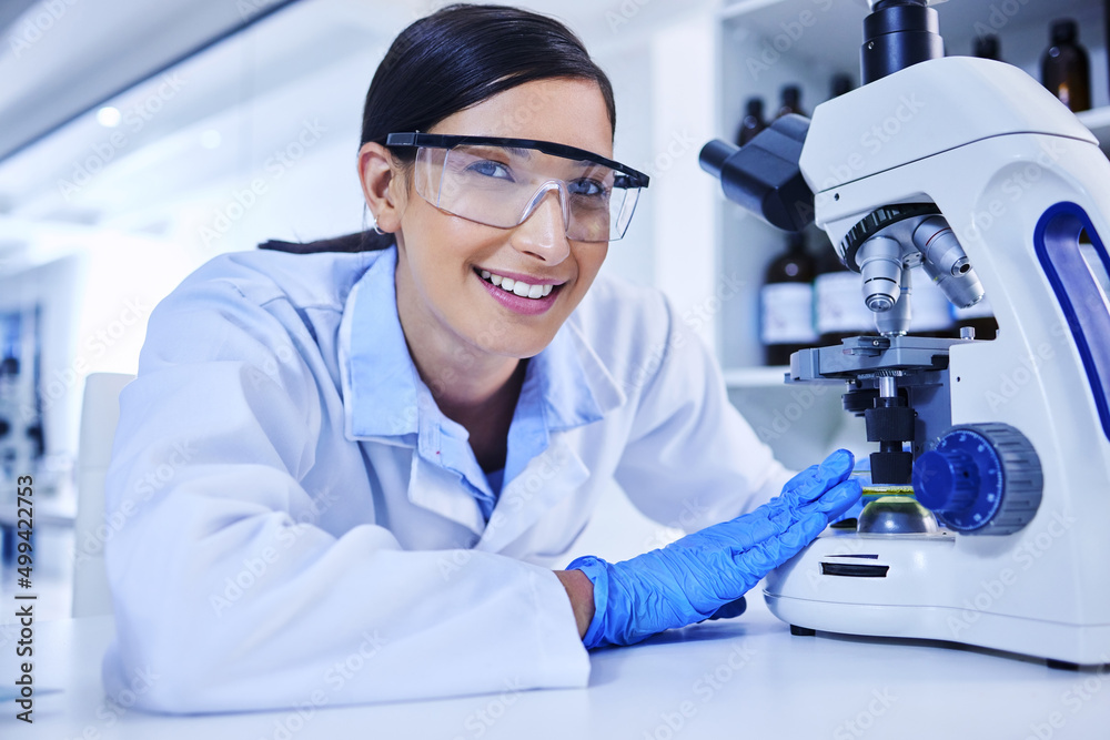 Poster my trusty lab partner. cropped portrait of an attractive young female scientist working with a micro