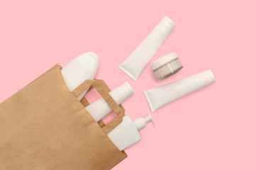 Craft paper bag with cosmetics in white containers. Place for text.