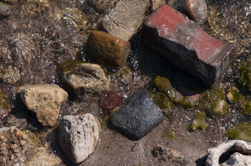 close up of rocks and bricks on the beach
