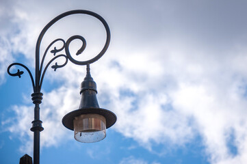 Beautiful forged lantern in the old city against the blue sky