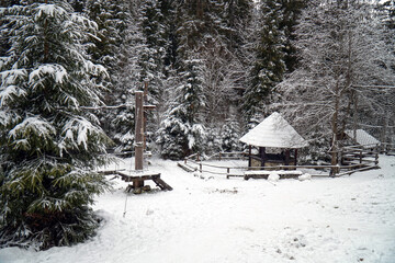 A gazebo in a snow-covered winter forest in the Carpathian Mountains.