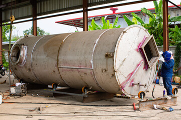 Fototapeta na wymiar Welding arc argon worker male repaired metal is welding sparks industrial construction tank