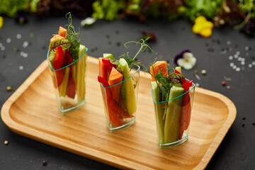 Colorful slices of raw vegetables in glasses (carrots, cucumber, sweet pepper). The concept of diet, healthy and vegetarian food.