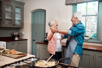 Eat good food and laugh good laughs. Cropped shot of a senior couple dancing while cooking in the kitchen at home.