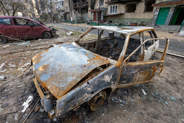 Irpen city, Ukraine, April 11, 2022. War of Russia against Ukraine. Burnt out car in the yard of a residential building