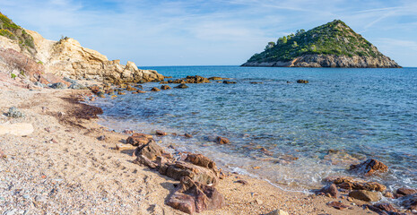 Fototapeta na wymiar Empty beach in Argentario region, Tuscany, Italy. Sand bay in natural park, island in mediterranean sea blue waving water