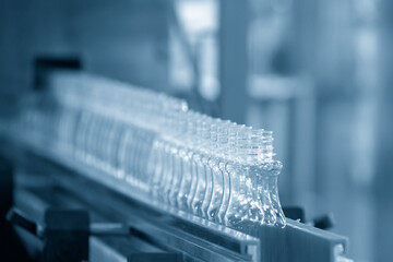 The empty PET bottles  on the conveyor belt for filling process in the drinking water factory.