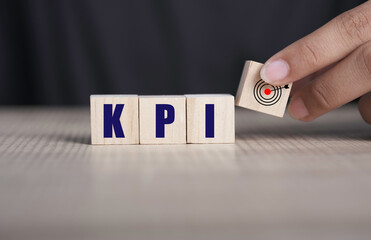 KPI, Key Performance Indicator concept. KPI text and taget icon in wooden cube block on table For business planning and measure success, target achievement. Copy space.