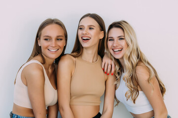 Group of women laughing together on white background.