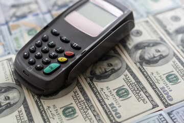 Terminal for cashless payments. Concept - refusal of cash transactions. Hundred dollar bills near...