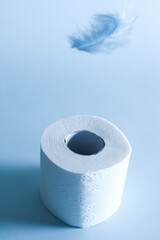 Toilet paper with blue steam over a feather, toilet paper on a blue background, soft like feather paper