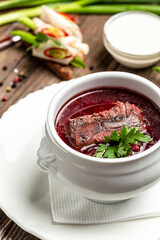 Borsch, soup, beet broth with vegetables and ribs, Traditional Ukrainian cuisine, wooden background. vertical image. top view. place for text