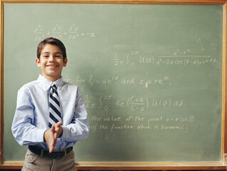 Portrait of boy (12-13) in front of chalkboard